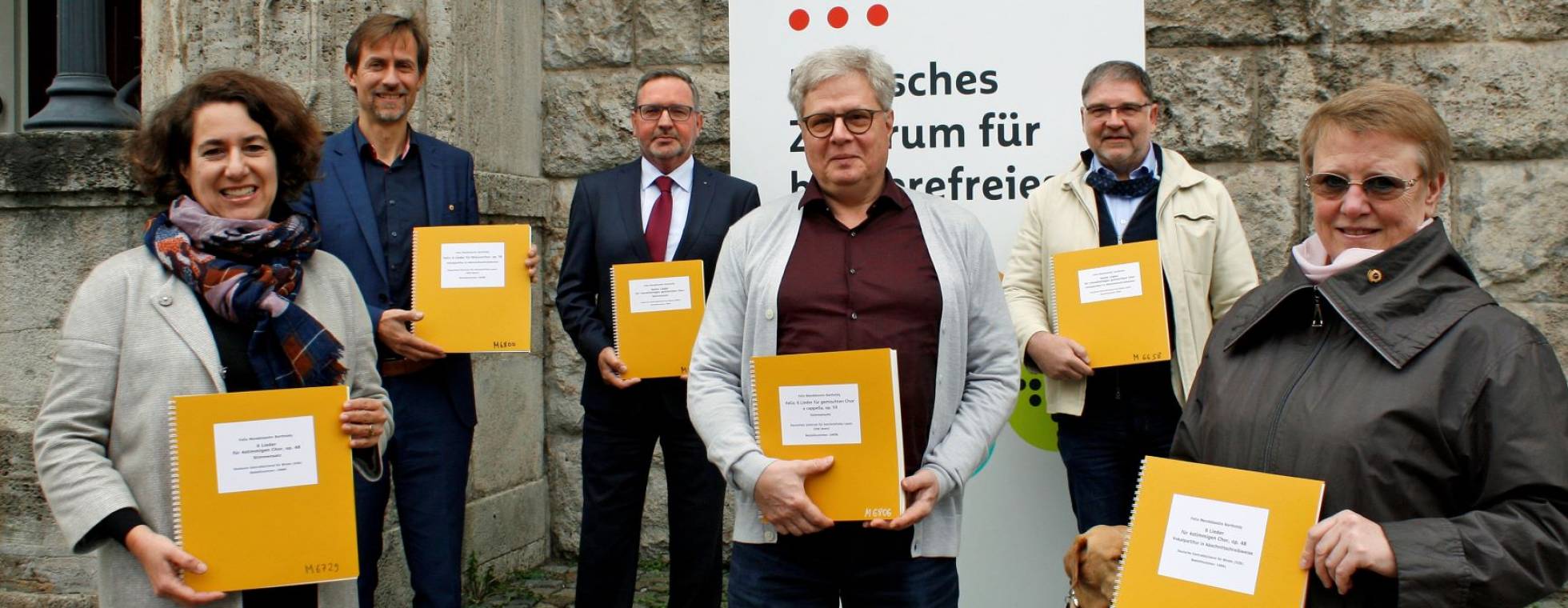 6 Personen stehen vor dem eingangsportal des dzb lesen